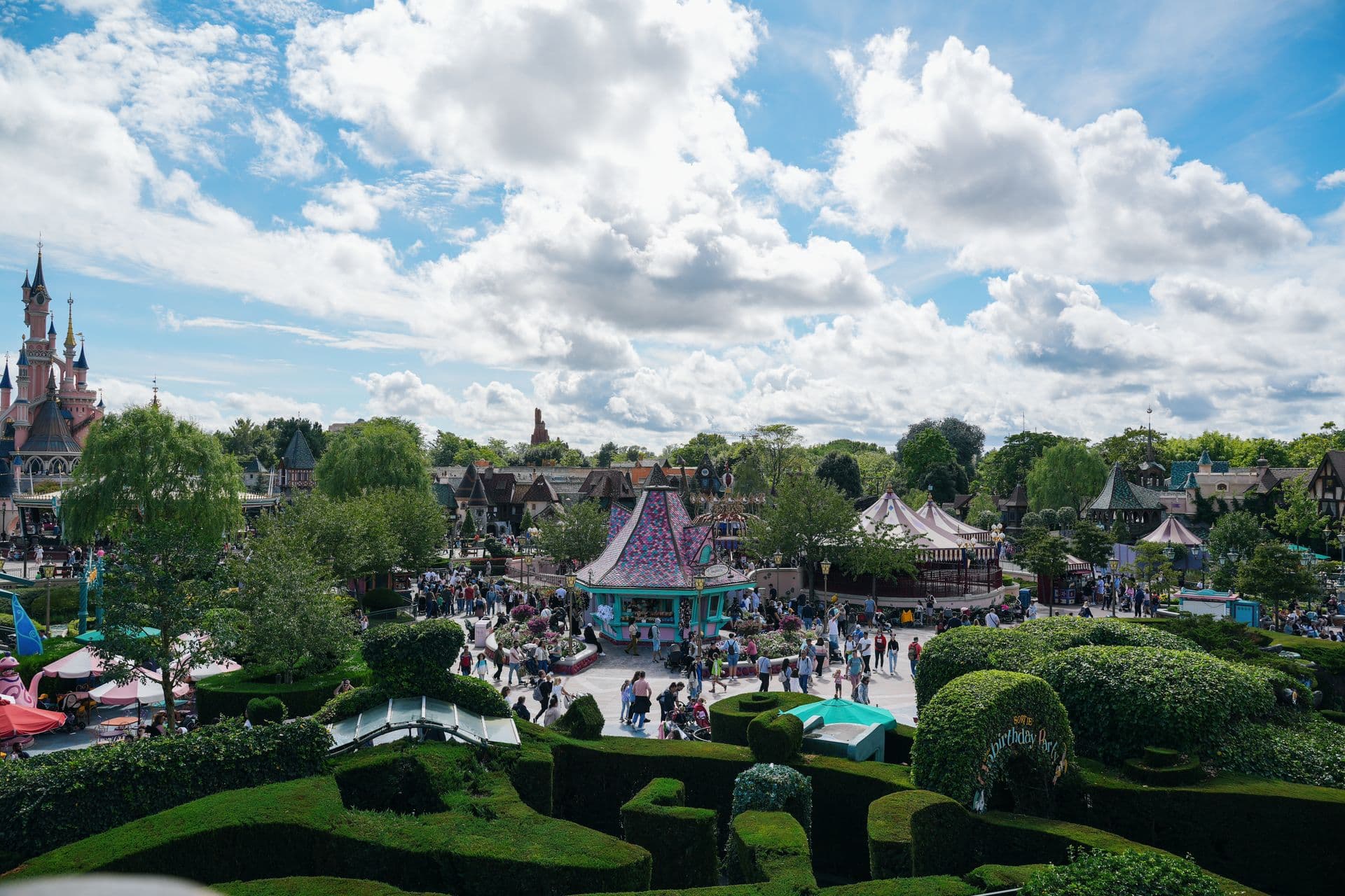 Зона Fantasyland в парижском Диснейленде с лабиринтом и замком вдали, фото Caspi Tours